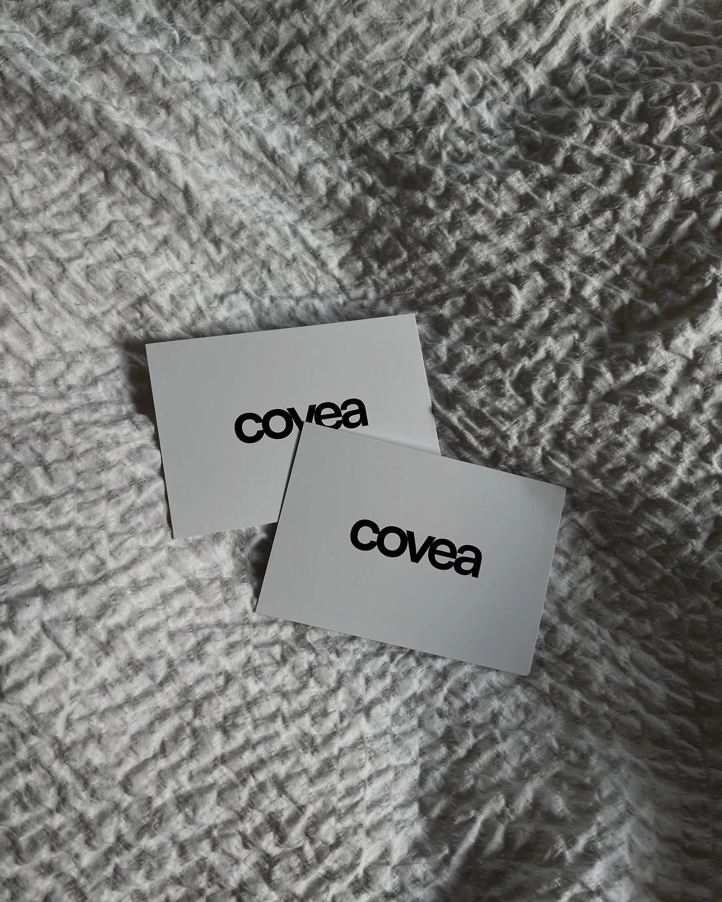 COVEA business cards on grey crinkled linen